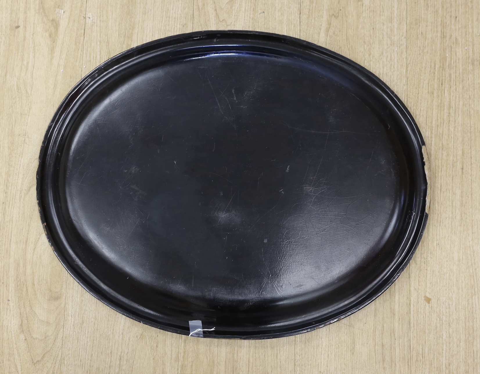 A Regency oval gilt and japanned papier mache tray, designed with a thistle border, 63cm wide